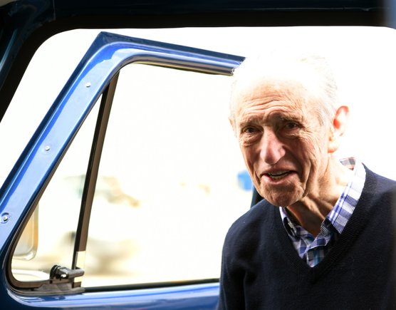 Fred Currey smiling next to his restored truck - pure joy