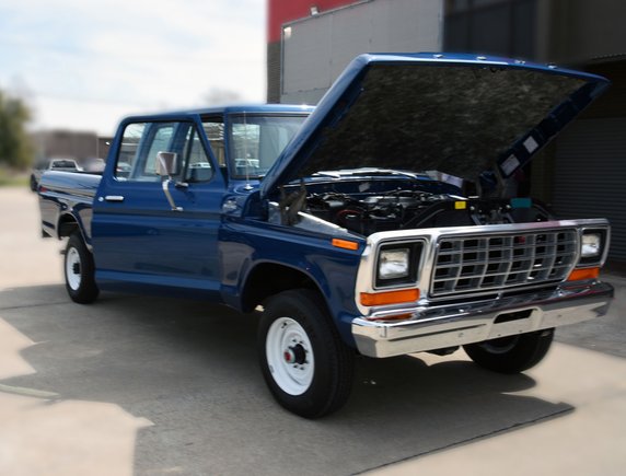 Front view of completed truck with hood open showing engine bay